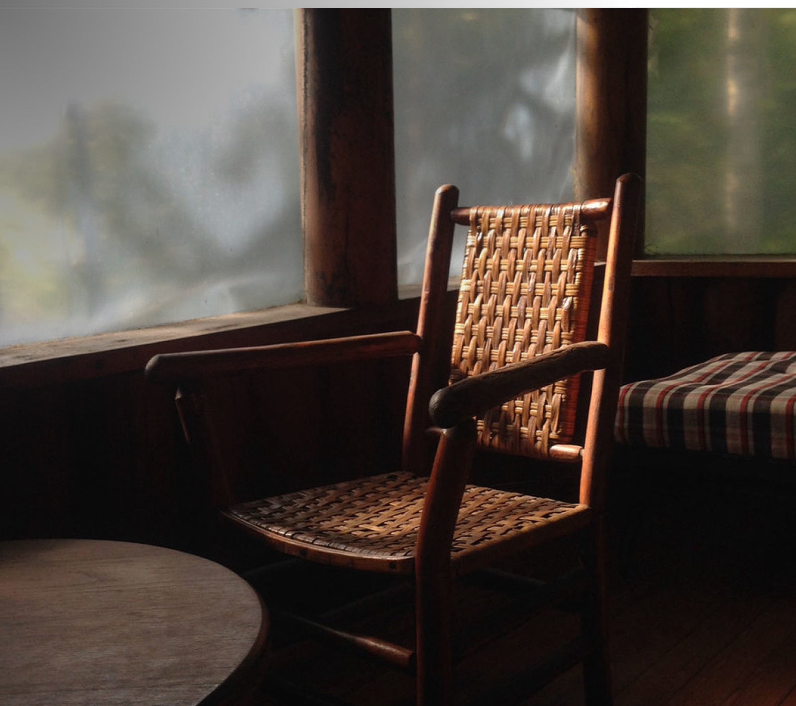 A quiet room with a woven chair by a window in soft morning light